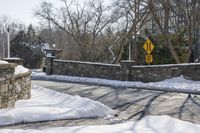 a road blocked by rock walls and trees in winter time in a town area with snow