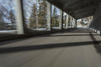 a blurry image of a road in an tunnel with rain, as viewed from the front seat of a car