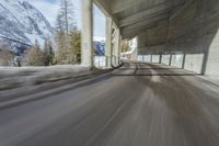 a blurry image of a road in an tunnel with rain, as viewed from the front seat of a car