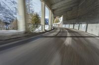 a blurry image of a road in an tunnel with rain, as viewed from the front seat of a car