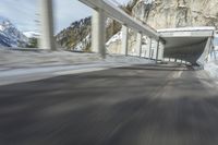 a blurry image of a road in an tunnel with rain, as viewed from the front seat of a car