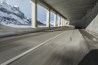 a blurry image of a road in an tunnel with rain, as viewed from the front seat of a car