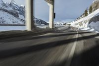 a blurry image of a road in an tunnel with rain, as viewed from the front seat of a car