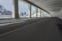 a blurry image of a road in an tunnel with rain, as viewed from the front seat of a car