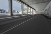 a blurry image of a road in an tunnel with rain, as viewed from the front seat of a car