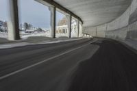 a blurry image of a road in an tunnel with rain, as viewed from the front seat of a car