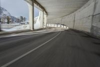 a blurry image of a road in an tunnel with rain, as viewed from the front seat of a car