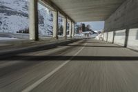 a blurry image of a road in an tunnel with rain, as viewed from the front seat of a car