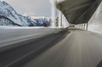 a blurry image of a road in an tunnel with rain, as viewed from the front seat of a car