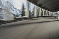 a blurry image of a road in an tunnel with rain, as viewed from the front seat of a car