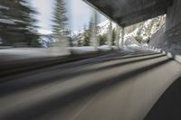 a blurry image of a road in an tunnel with rain, as viewed from the front seat of a car