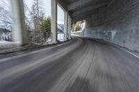 a blurry image of a road in an tunnel with rain, as viewed from the front seat of a car