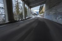 a blurry image of a road in an tunnel with rain, as viewed from the front seat of a car