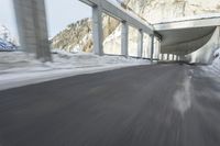 a blurry image of a road in an tunnel with rain, as viewed from the front seat of a car