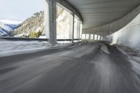 a blurry image of a road in an tunnel with rain, as viewed from the front seat of a car