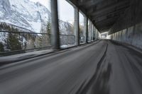 a blurry image of a road in an tunnel with rain, as viewed from the front seat of a car