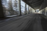 a blurry image of a road in an tunnel with rain, as viewed from the front seat of a car