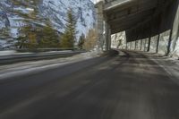 a blurry image of a road in an tunnel with rain, as viewed from the front seat of a car