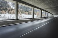 a blurry image of a road in an tunnel with rain, as viewed from the front seat of a car