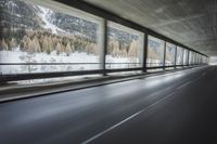 a blurry image of a road in an tunnel with rain, as viewed from the front seat of a car