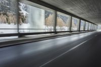 a blurry image of a road in an tunnel with rain, as viewed from the front seat of a car