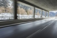 a blurry image of a road in an tunnel with rain, as viewed from the front seat of a car