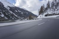 a snow covered mountain is in the background while a car drives down the road in a blur