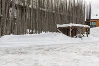 a snowboarder riding in the snow under a covered shelter under a grey sky