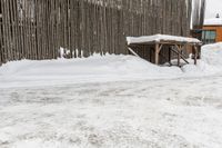 a snowboarder riding in the snow under a covered shelter under a grey sky