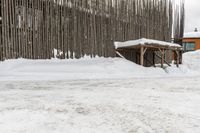 a snowboarder riding in the snow under a covered shelter under a grey sky