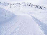 snow covered slope in the middle of a ski area as people ski on it near ski lift