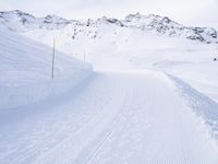 snow covered slope in the middle of a ski area as people ski on it near ski lift