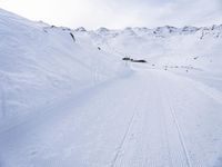 snow covered slope in the middle of a ski area as people ski on it near ski lift