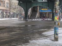 a man is walking on an empty city street in winter with bicycles parked on the side walk