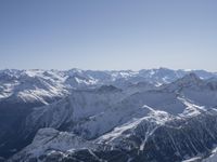 snow covered mountains are seen from a mountaintop with skis, poles and a line going through them