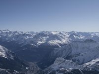 snow covered mountains are seen from a mountaintop with skis, poles and a line going through them