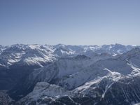 snow covered mountains are seen from a mountaintop with skis, poles and a line going through them