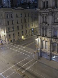 an empty city street at night as seen from a high angle view of the building