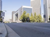 a woman rides a motorcycle in a motion on the side of the street with tall buildings