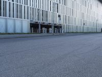 a woman in black shirt riding a skateboard down a city street corner in front of large tall buildings