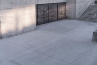 a woman riding a skateboard on top of a sidewalk next to two doors of an office