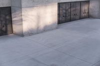 a woman riding a skateboard on top of a sidewalk next to two doors of an office