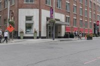 a woman rides a skateboard down the street in front of the red brick building