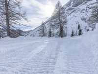 a woman riding skis down the side of a snow covered mountain road at high speed