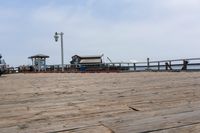 the wooden floor of a pier with a yellow surf board in the water behind it