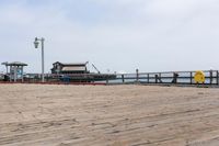 the wooden floor of a pier with a yellow surf board in the water behind it