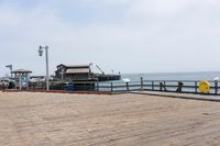 the wooden floor of a pier with a yellow surf board in the water behind it