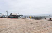 the wooden floor of a pier with a yellow surf board in the water behind it