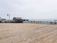 the wooden floor of a pier with a yellow surf board in the water behind it