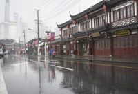 a woman walks through an alley in the rain holding an umbrella on a rainy day